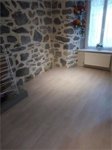 Parquet clair posé dans une pièce aux murs en pierre d'Auvergne